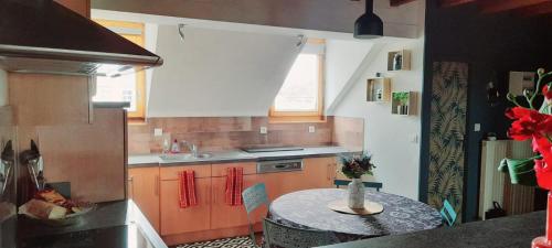 - une cuisine avec une table ronde dans l'établissement Appartement l'abstrait, à Villersexel