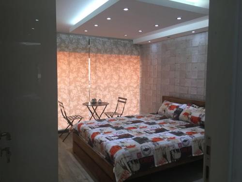 Un dormitorio con una cama y una mesa. en Chalet in Solemar,renovated,parking,Wifi elec247 en Jounieh