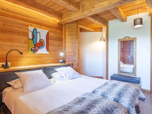 a bedroom with two beds in a room with wooden walls at Chalet skis aux pieds avec spa et sauna, Alpe d'Huez - FR-1-645-41 in LʼHuez