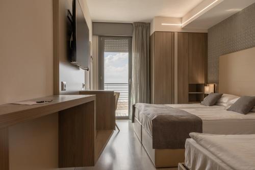a hotel room with two beds and a window at Hotel Delle Nazioni - Adults Only in Caorle