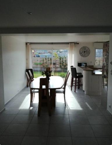 une cuisine et une salle à manger avec une table et des chaises dans l'établissement Maison port-en-bessin, à Port-en-Bessin-Huppain