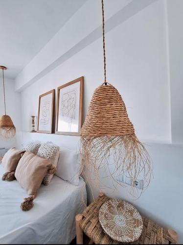 een slaapkamer met een bed en een hanglamp bij Apartamento Boho Chic in Denia