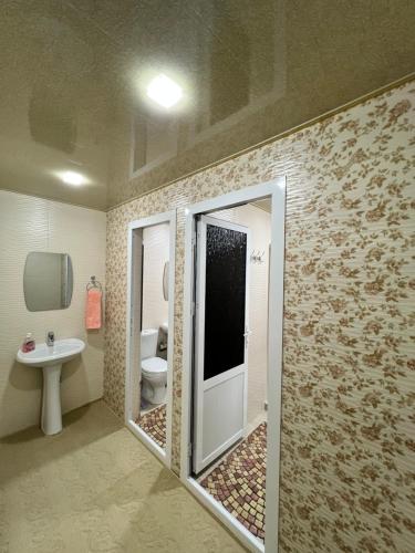 een badkamer met een douche, een toilet en een wastafel bij MrShox Hostel in Samarkand