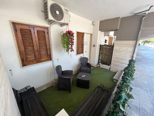 Habitación con balcón con sillas y ventilador. en Sunset Apartment Palese - A 10m dal mare, en Bari