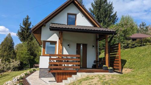 a small house on a hill with a porch at Cichata - domek w Bieszczadach in Czarna