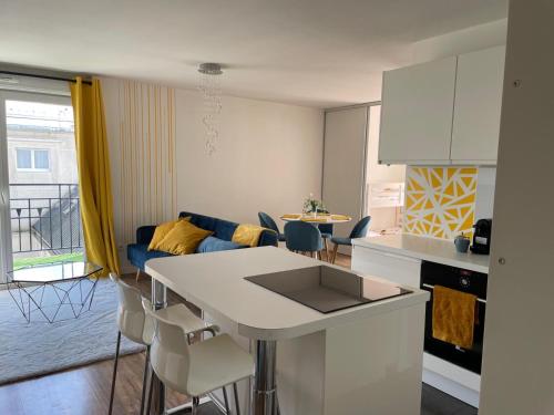 une cuisine et un salon avec un canapé et une table dans l'établissement Appartement 3P Gare Terrasse et Parking privé, à Franconville