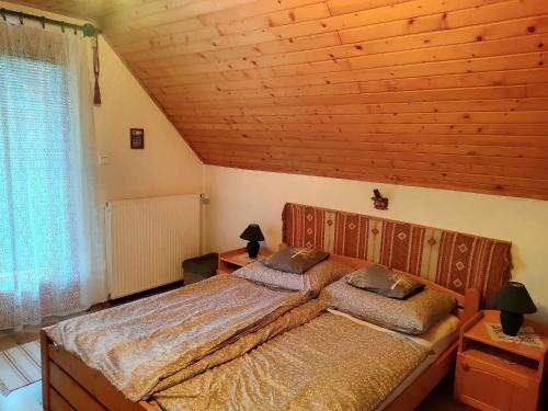 a bedroom with a bed with two pillows on it at Pipacs ház in Balatonlelle