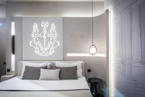 a bedroom with a white bed with a painting on the wall at Lavris City Suites in Heraklio Town