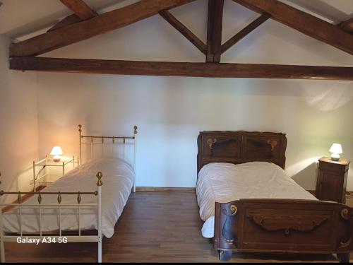 a bedroom with two beds and wooden beams at La maison d'Amelie in Montesquieu-Volvestre