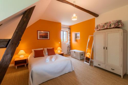 a bedroom with a white bed and orange walls at Maison Les Deux Ailes, Parc arboré, billard et wifi à 1h30 de Paris in Triguères
