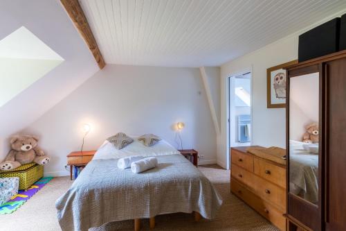 a bedroom with a bed and a dresser and a mirror at Maison Les Deux Ailes, Parc arboré, billard et wifi à 1h30 de Paris in Triguères