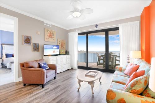 a living room with a couch and a table at Grand Pointe 502- Gulf-front water on 2 sides in Orange Beach