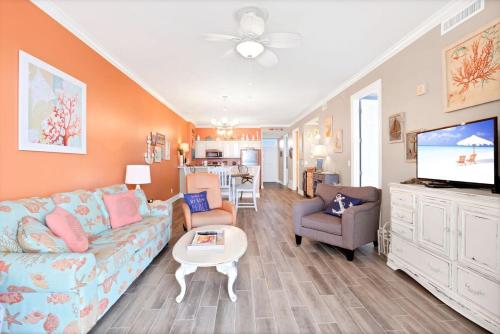 a living room with a couch and a tv at Grand Pointe 502- Gulf-front water on 2 sides in Orange Beach