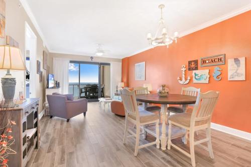 a dining room and living room with a table and chairs at Grand Pointe 502- Gulf-front water on 2 sides in Orange Beach