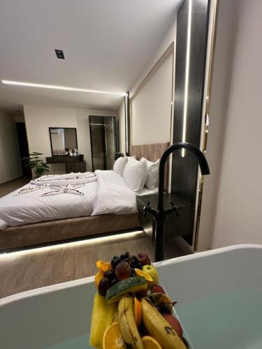 a room with a bed and a plate of fruit on a counter at Crowne Pyramids View inn in Cairo