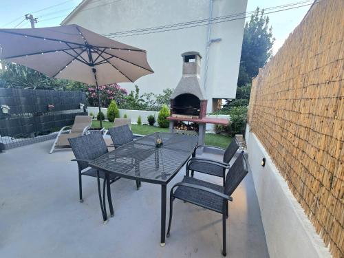 a patio with a table and chairs and an outdoor oven at Apartmani Krnić in Šibenik