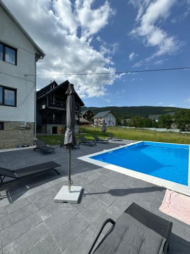 a patio with an umbrella and a swimming pool at GARAGE in Yaremche