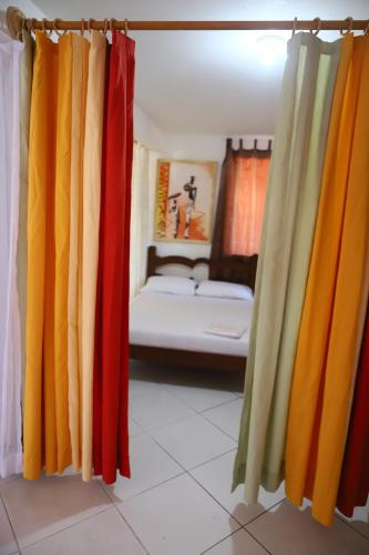 a room with colorful curtains and a bed at Loft Rústico com Piscina e Churrasqueira in Aquiraz