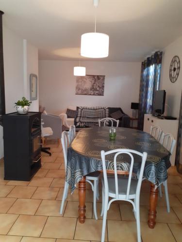 a dining room and living room with a table and chairs at Gite de la plage proche de la Saône in Autet