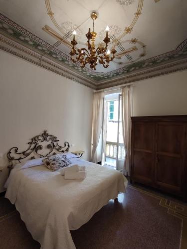 a bedroom with a large bed with a chandelier at Residenza d'Epoca Senatore Rolandi Ricci in Albenga