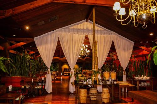 a room with a table with white drapes at Hotel Raices Esturion in Puerto Iguazú