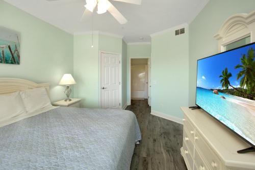 a bedroom with a large screen tv and a bed at Dunes Club 1A by Pristine Properties Vacation Rentals in Cape San Blas