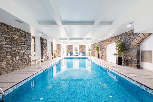a swimming pool in a building with a stone wall at The Atholl Palace in Pitlochry