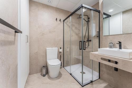a bathroom with a shower and a toilet and a sink at CMDreams Platinium- Apartamentos turísticos en el centro de Mérida in Merida
