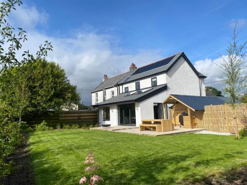 a white house with a large yard with a yard at Beautiful 3 Bedroom Home, North Cornwall in Saint Teath