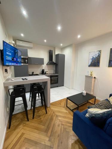 Il comprend une cuisine et un salon doté d'un canapé bleu. dans l'établissement Appart Cosy, Proche Gare, à Nice