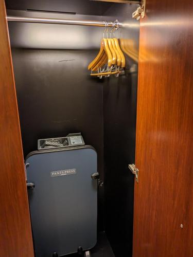 a locker room with a suitcase and some baseball bats at ホテル リズコート HOTEL Liz court in Sendai
