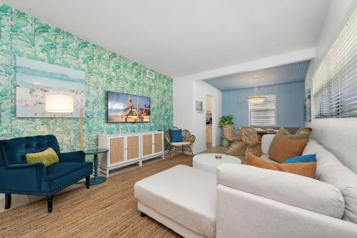 Una sala de estar con un sofá blanco y sillas azules. en Walk to Beach, Heated Pool, Dog-Friendly, Firepit, en Daytona Beach