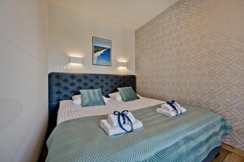 a bedroom with two beds with towels on them at Aparthotel Anchoria BlueApart in Mechelinki