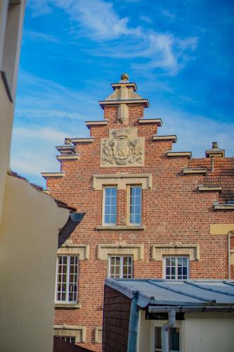 a tall brick building with a clock on it at Chateau Compiegne Houses - Centre Ville in Compiègne
