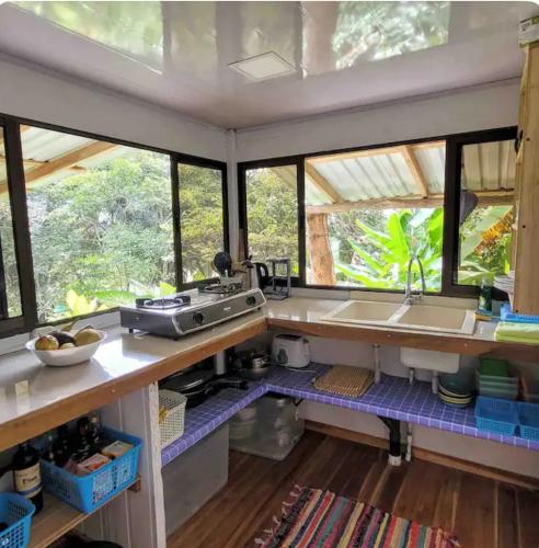 a kitchen with windows and a counter with a sink at Beachfront tiny Bungalow in Boca de Ario