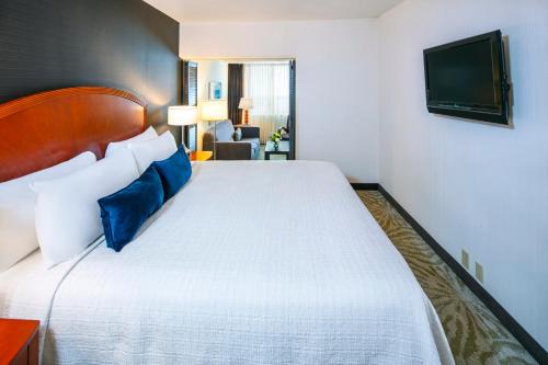 a hotel room with a large bed with blue pillows at Cambridge Suites Hotel Halifax in Halifax