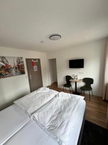 a bedroom with a bed and a table and chairs at Sleep & Go Motel in Unterbalbach