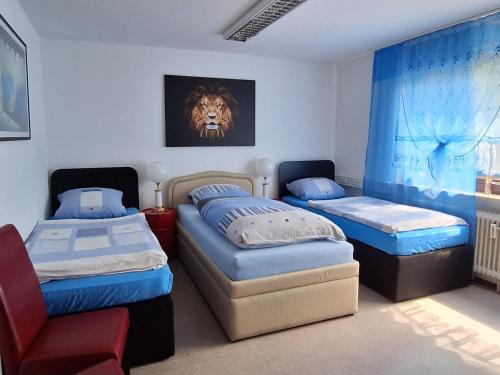 ein Zimmer mit 2 Betten und einem Stuhl darin in der Unterkunft Pension beim Kastell in Sulz am Neckar