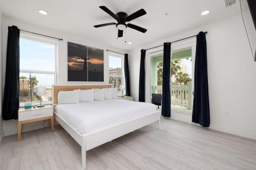 Schlafzimmer mit einem weißen Bett und einem Deckenventilator in der Unterkunft Marisol Condo 301 in South Padre Island