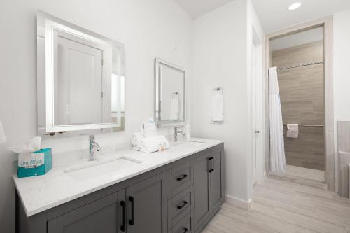 ein weißes Bad mit einem Waschbecken und einer Dusche in der Unterkunft Marisol Condo 301 in South Padre Island