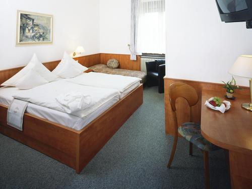 a hotel room with a bed and a desk at Haus Von Der Heyde in Iserlohn