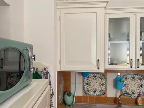 a kitchen with white cabinets and a sink at LA CONCHIGLIA - Sirolo Suite in Sirolo