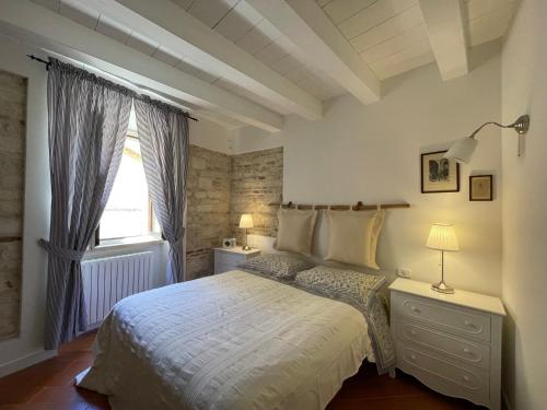 una camera con un letto bianco e una finestra di La Cialdina - La CONCHIGLIA Sirolo Apartment a Sirolo