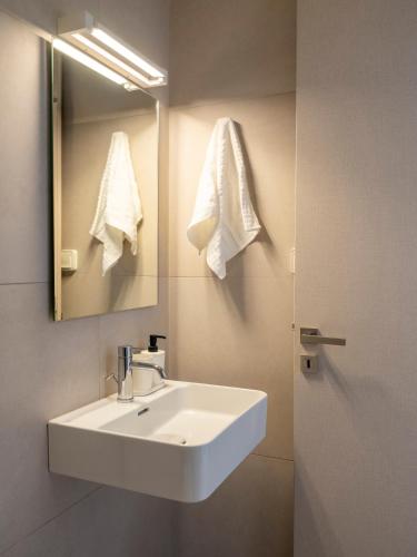 a bathroom with a white sink and a mirror at Amouage Studios in Kampos Paros