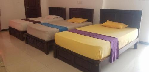 two twin beds in a room with at Akoya Pearl Hotel in Lellopitiya