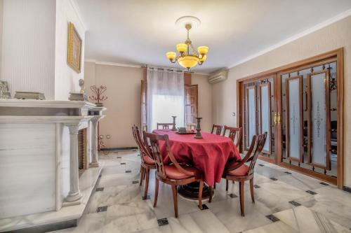 een eetkamer met een tafel en stoelen en een kroonluchter bij Casa con patio María Auxiliadora in Córdoba