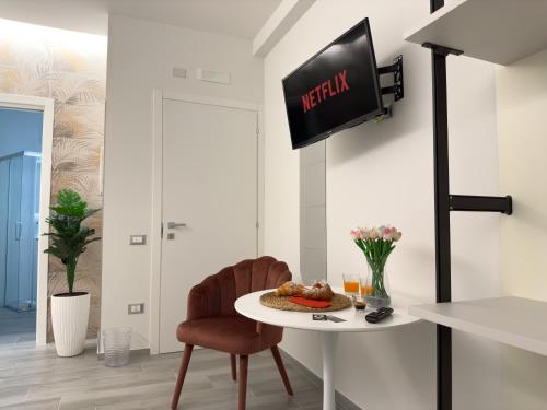 a room with a table and a tv on the wall at Al Civico3 Home & Suites in Salerno