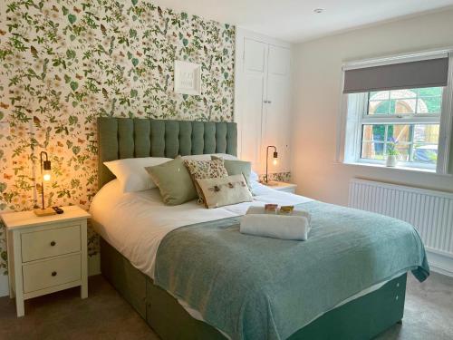 a bedroom with a bed with a green headboard at North Lodge at Quex Park in Birchington