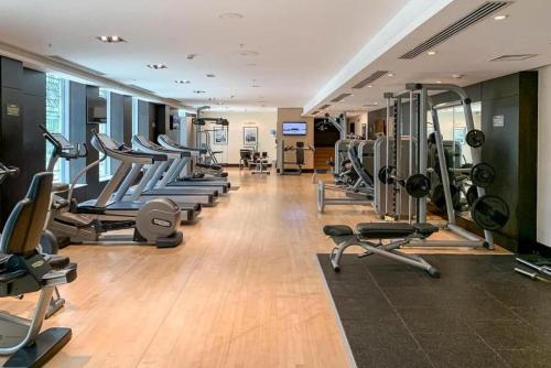a gym with a row of treadms and machines at The residences 1 - Luxury 1BR apt in Downtown Dubai - 2 mins walk to Burj Khalifa & Dubai Mall in Dubai