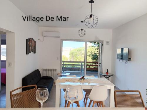 a living room with a dining room table and chairs at Village de Mar in Monte Hermoso